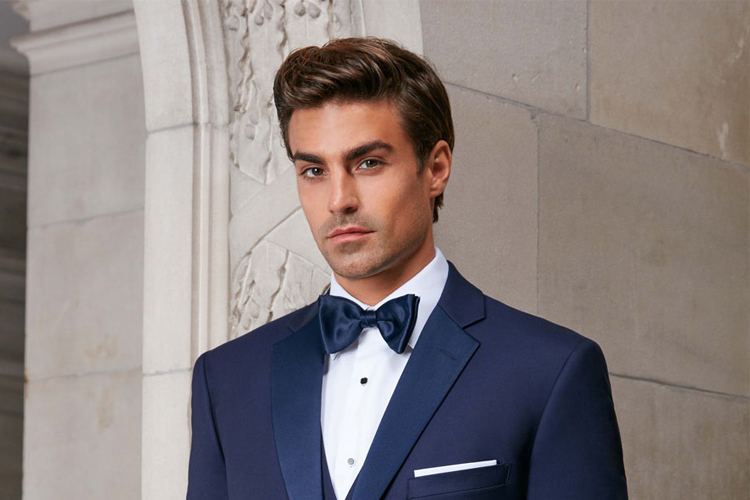 Man in navy tuxedo with bow tie.