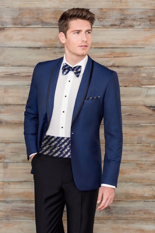 Man in blue tuxedo, patterned bow tie.