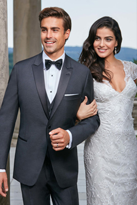 Here's an 8-word alt tag for the image: Groom in tuxedo with bride in wedding dress.