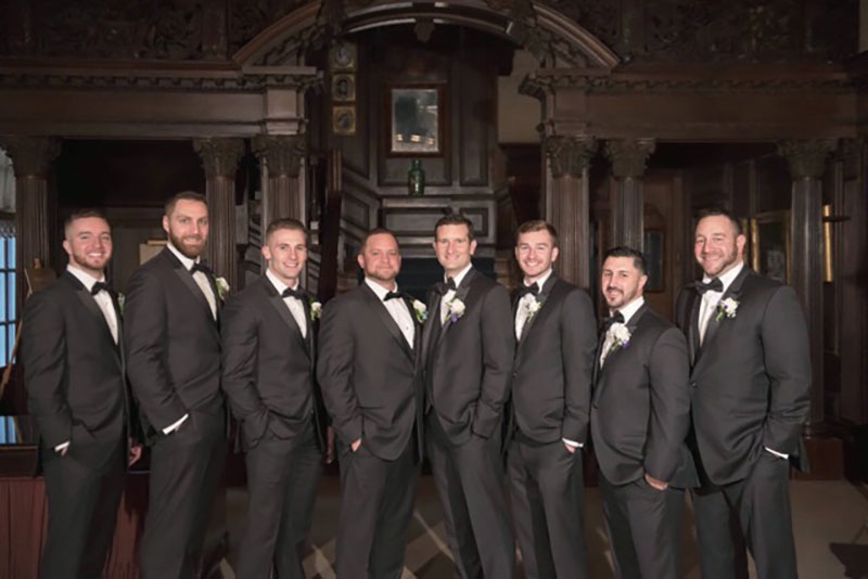Groomsmen in black tuxedos at wedding.