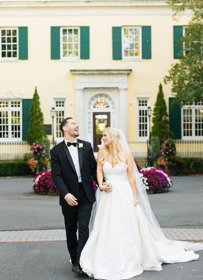 Happy wedding couple outside mansion.