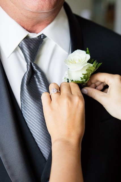 Groom's boutonniere and ring detail.