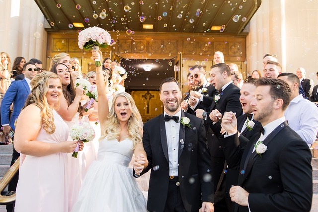 Bride and groom exit church, bubble send-off.