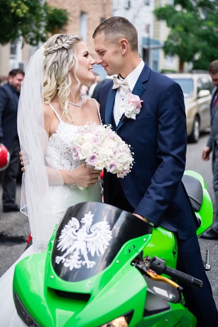 Bride and groom by green motorcycle.